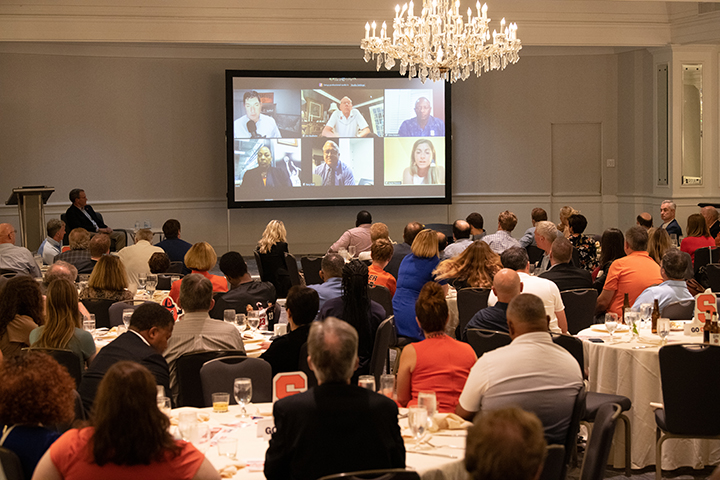 Guests watch the coaches on a panel via Zoom.